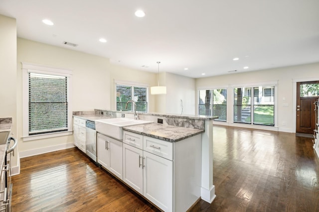 kitchen featuring dark wood-type flooring, sink, white cabinetry, stainless steel dishwasher, and pendant lighting