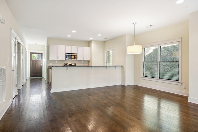 kitchen featuring decorative light fixtures, kitchen peninsula, dark hardwood / wood-style floors, and white cabinets