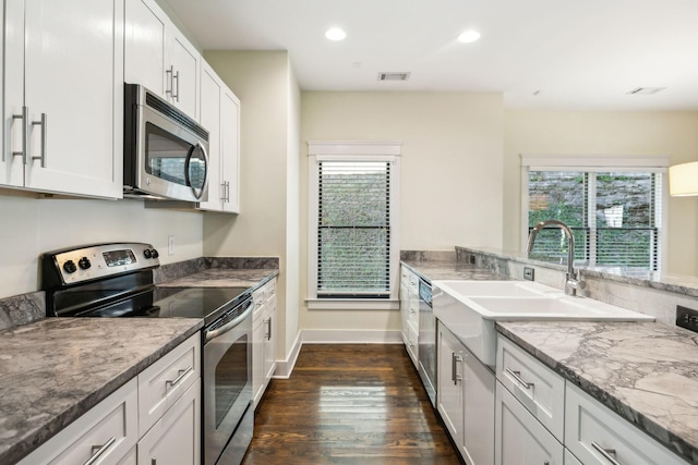 kitchen featuring dark hardwood / wood-style floors, white cabinetry, sink, light stone counters, and stainless steel appliances