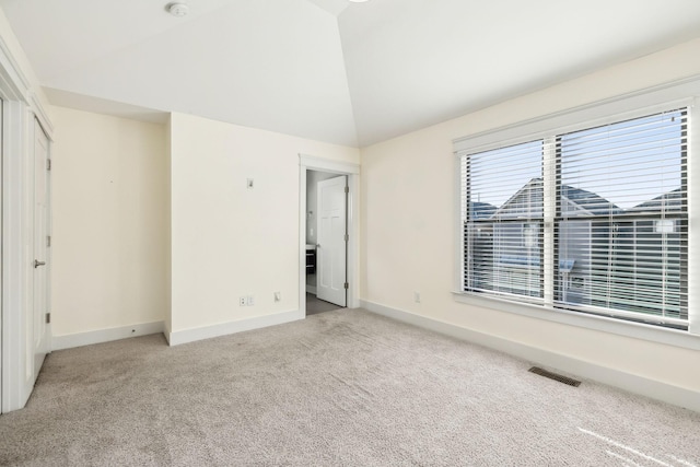 unfurnished bedroom featuring lofted ceiling and light colored carpet