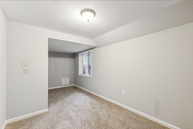 spare room with carpet floors and vaulted ceiling