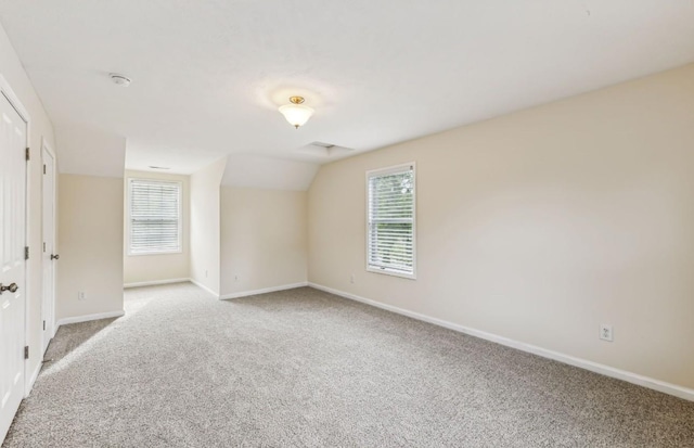 carpeted empty room featuring lofted ceiling and a healthy amount of sunlight