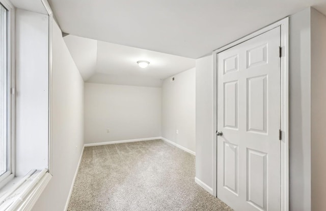 interior space with light colored carpet and lofted ceiling