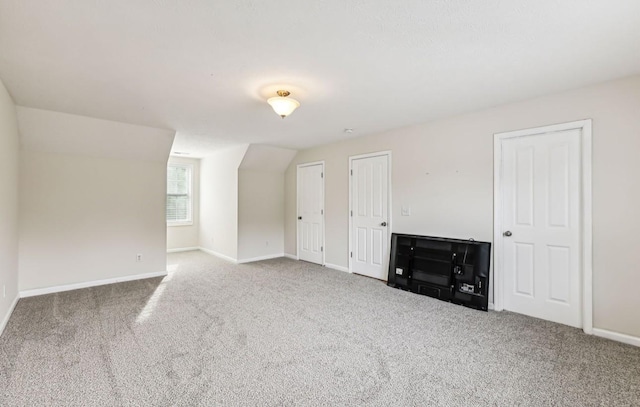 bonus room with carpet floors and vaulted ceiling