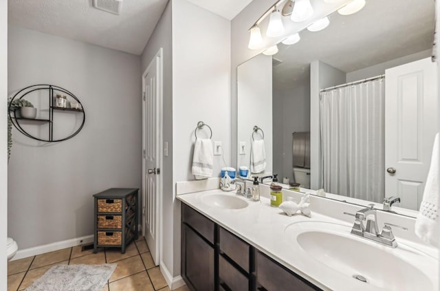 bathroom featuring tile patterned flooring, vanity, and toilet