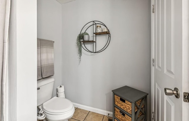 bathroom featuring washer / dryer, tile patterned flooring, and toilet