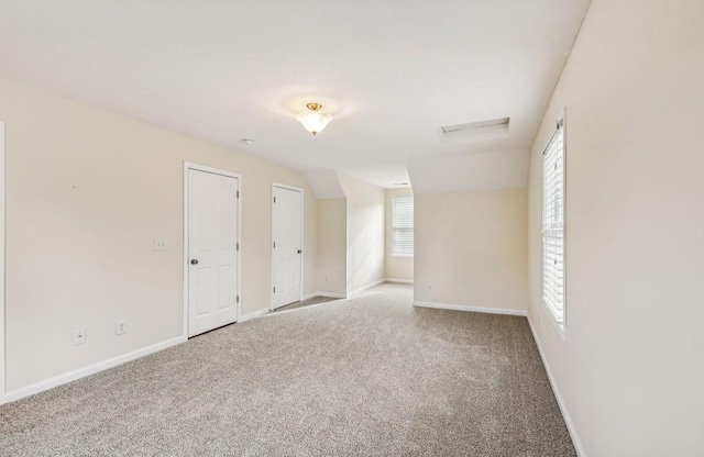 empty room with carpet and vaulted ceiling