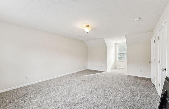 spare room featuring light carpet and lofted ceiling