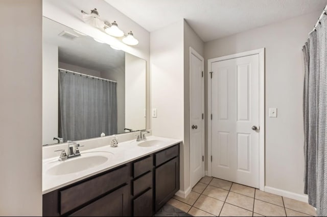 bathroom featuring a textured ceiling, vanity, and tile patterned floors