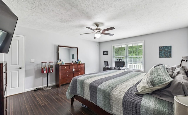 bedroom with a textured ceiling, ceiling fan, and dark wood-type flooring