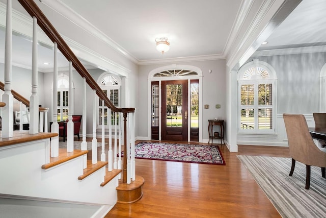 foyer entrance with crown molding and hardwood / wood-style flooring