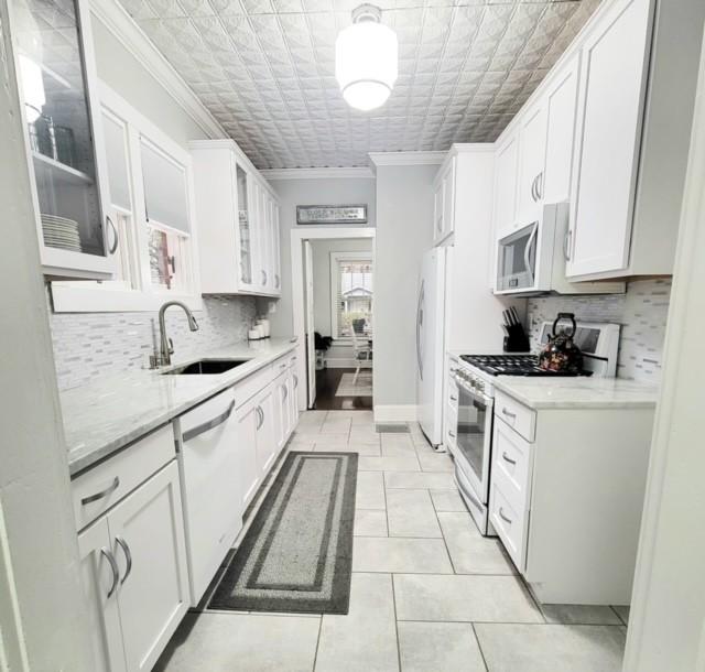 kitchen with white cabinetry, sink, and white appliances