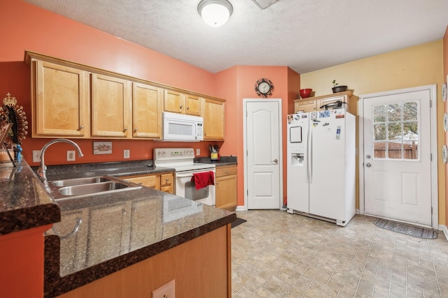 kitchen featuring a textured ceiling, kitchen peninsula, white appliances, and sink