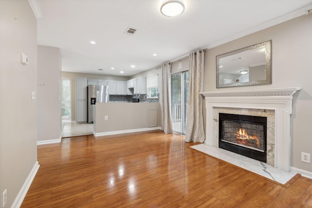 unfurnished living room with light hardwood / wood-style flooring and a high end fireplace