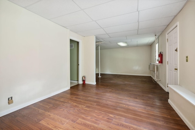 spare room featuring dark hardwood / wood-style floors and a drop ceiling