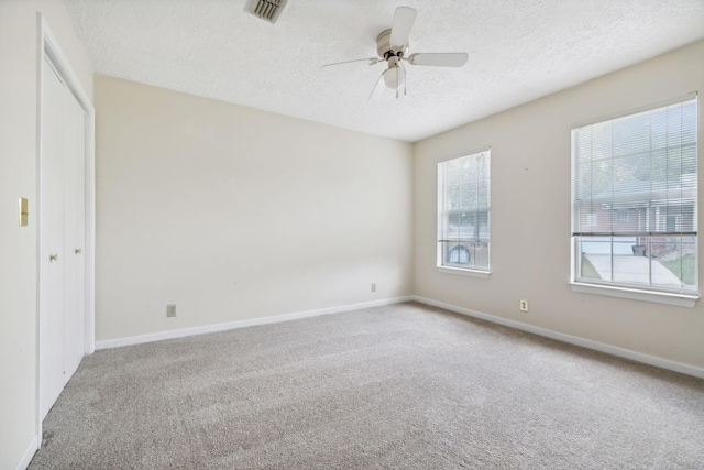 unfurnished room with carpet flooring, a textured ceiling, and ceiling fan