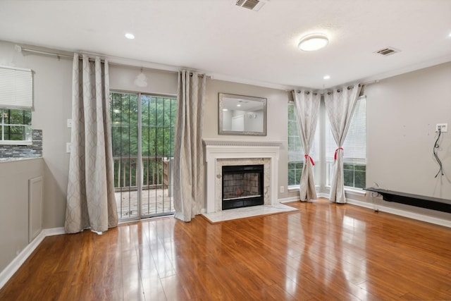 unfurnished living room featuring hardwood / wood-style flooring and a high end fireplace