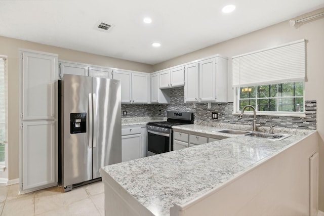 kitchen featuring kitchen peninsula, stainless steel appliances, white cabinets, and sink