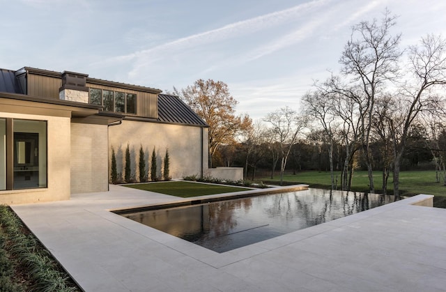 view of swimming pool with a patio and a lawn