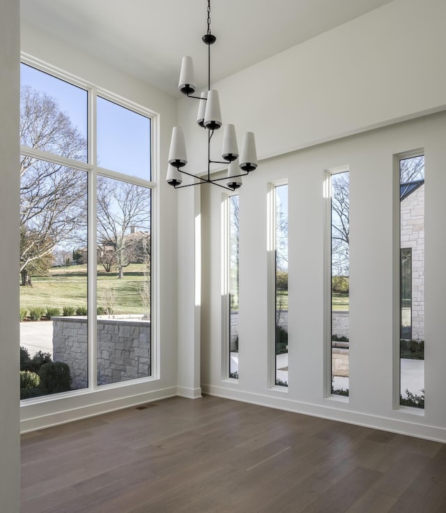 interior space with a notable chandelier, dark hardwood / wood-style floors, and plenty of natural light