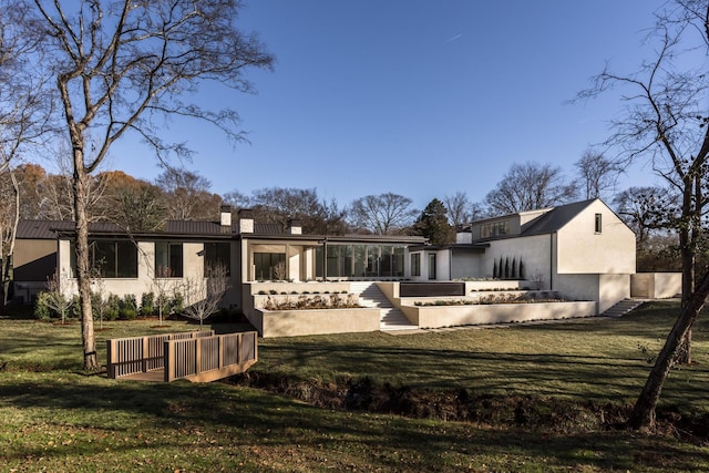 back of property featuring a lawn and a sunroom