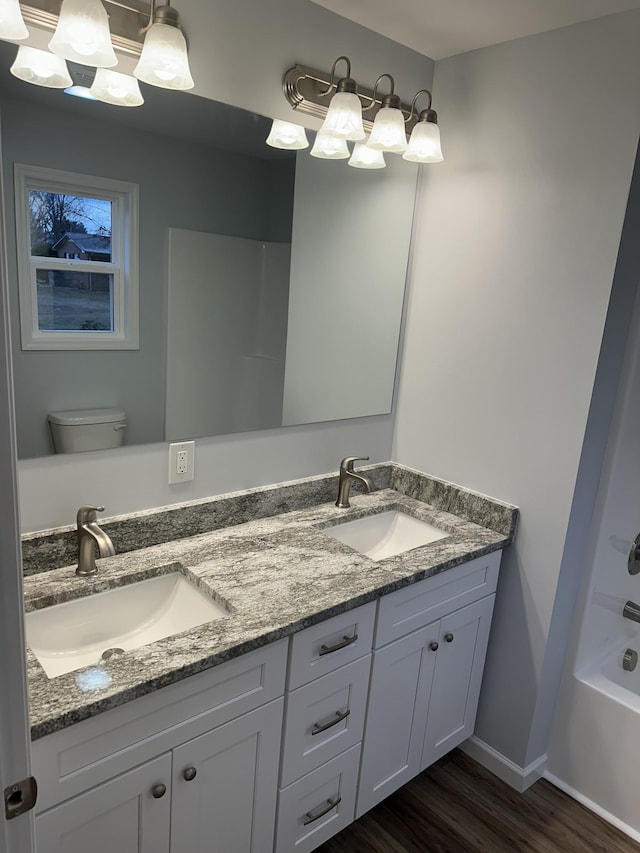 full bathroom with shower / tub combination, hardwood / wood-style floors, vanity, and toilet