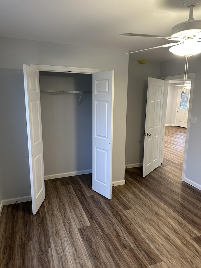 unfurnished bedroom with ceiling fan, dark hardwood / wood-style floors, and a closet