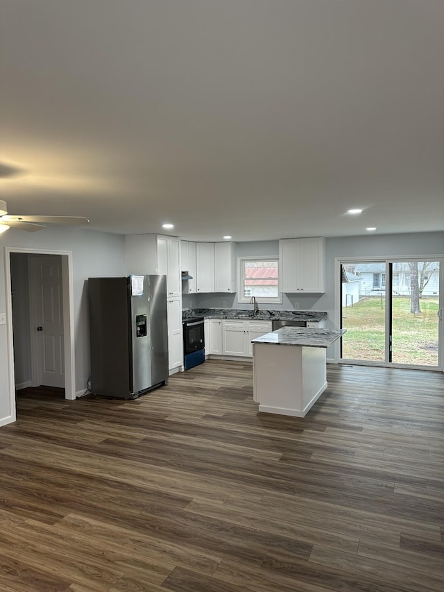 kitchen with white cabinets, dark wood-style floors, black electric range oven, stainless steel refrigerator with ice dispenser, and a sink