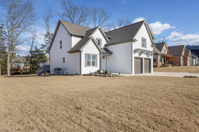 view of property featuring a garage and a front lawn