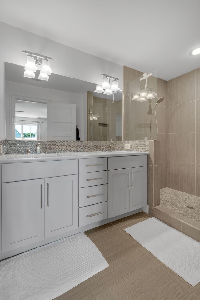 bathroom with decorative backsplash, vanity, and tiled shower