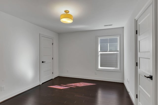 spare room with dark wood-type flooring