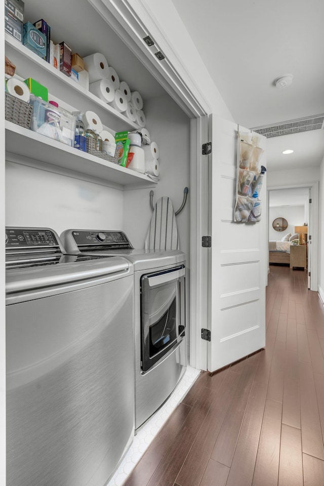 laundry room featuring dark wood-type flooring and washer and dryer