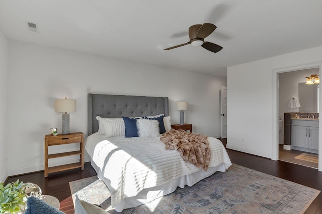 bedroom featuring ceiling fan, dark hardwood / wood-style floors, and ensuite bath