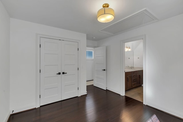 unfurnished bedroom with dark hardwood / wood-style flooring, ensuite bathroom, a closet, and sink