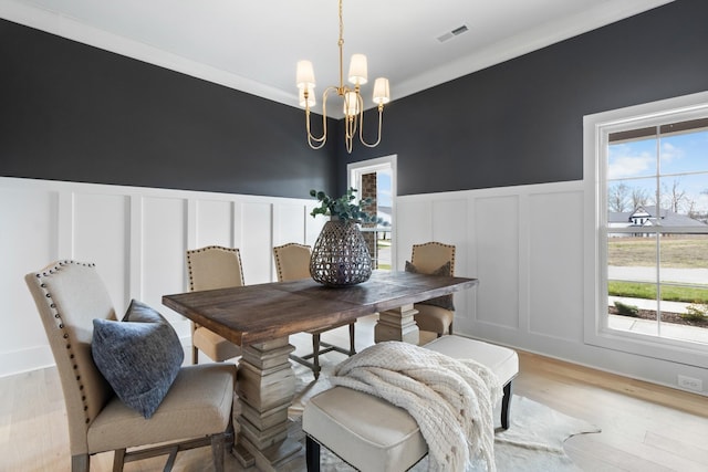 dining area with plenty of natural light, light wood-type flooring, and a notable chandelier