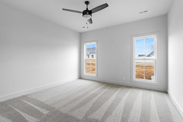 spare room featuring ceiling fan and carpet