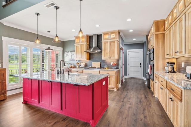 kitchen with wall chimney range hood, sink, decorative backsplash, decorative light fixtures, and light stone counters