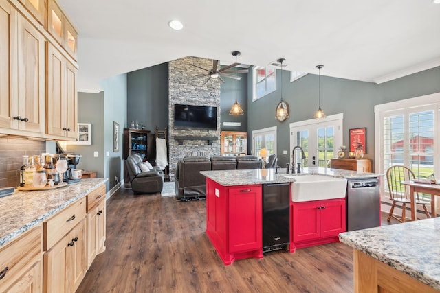 kitchen with a kitchen island with sink, ceiling fan, sink, dishwasher, and a stone fireplace