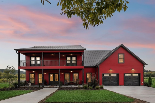 view of front of home featuring a yard, a balcony, a porch, and a garage