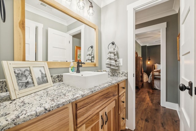 bathroom featuring vanity, wood-type flooring, and ornamental molding