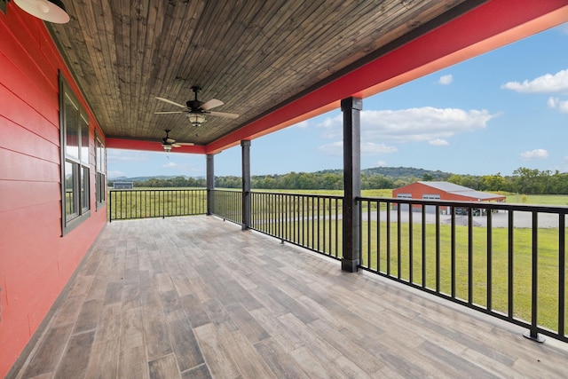 wooden deck featuring a lawn and ceiling fan