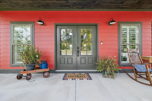 view of exterior entry with french doors and a porch