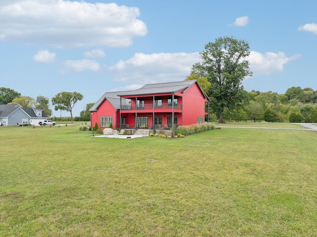 back of house with a lawn, a patio area, and a balcony