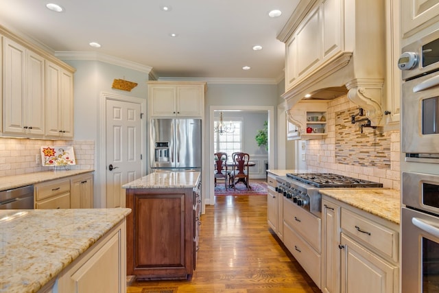 kitchen with decorative backsplash, light stone counters, wood-type flooring, and stainless steel appliances