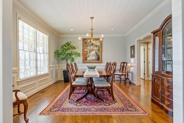 dining area featuring a chandelier, wood-type flooring, and crown molding