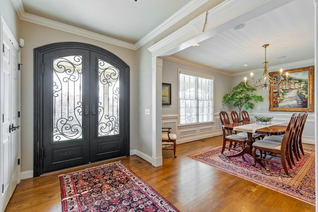 entryway featuring a chandelier, french doors, light hardwood / wood-style flooring, and crown molding