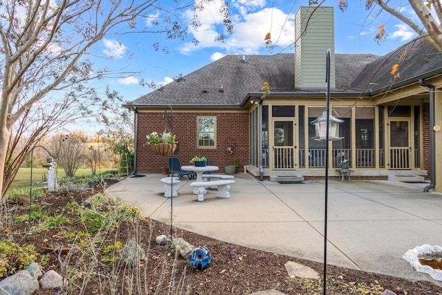 rear view of house featuring a patio and a sunroom