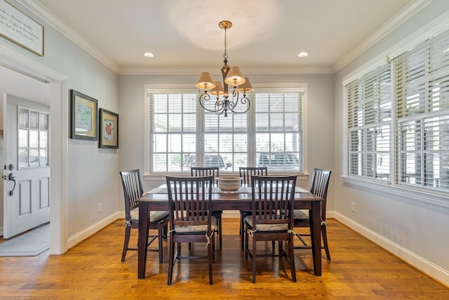 dining area featuring crown molding, a chandelier, and hardwood / wood-style flooring