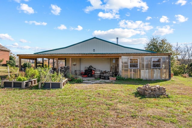 rear view of property featuring a yard and an outdoor structure