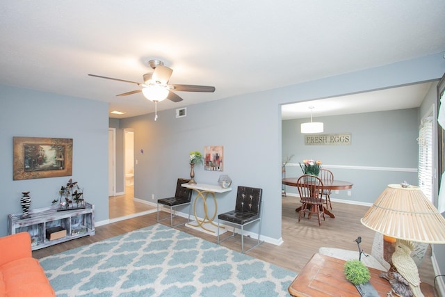 living room with ceiling fan and hardwood / wood-style floors